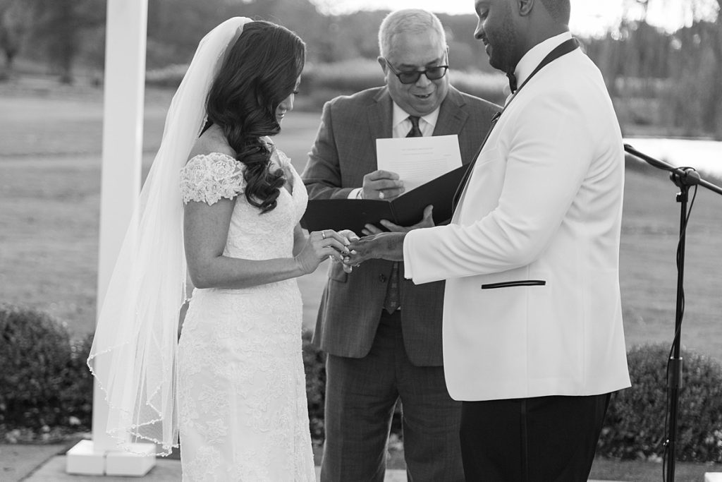 Bride places ring on Groom